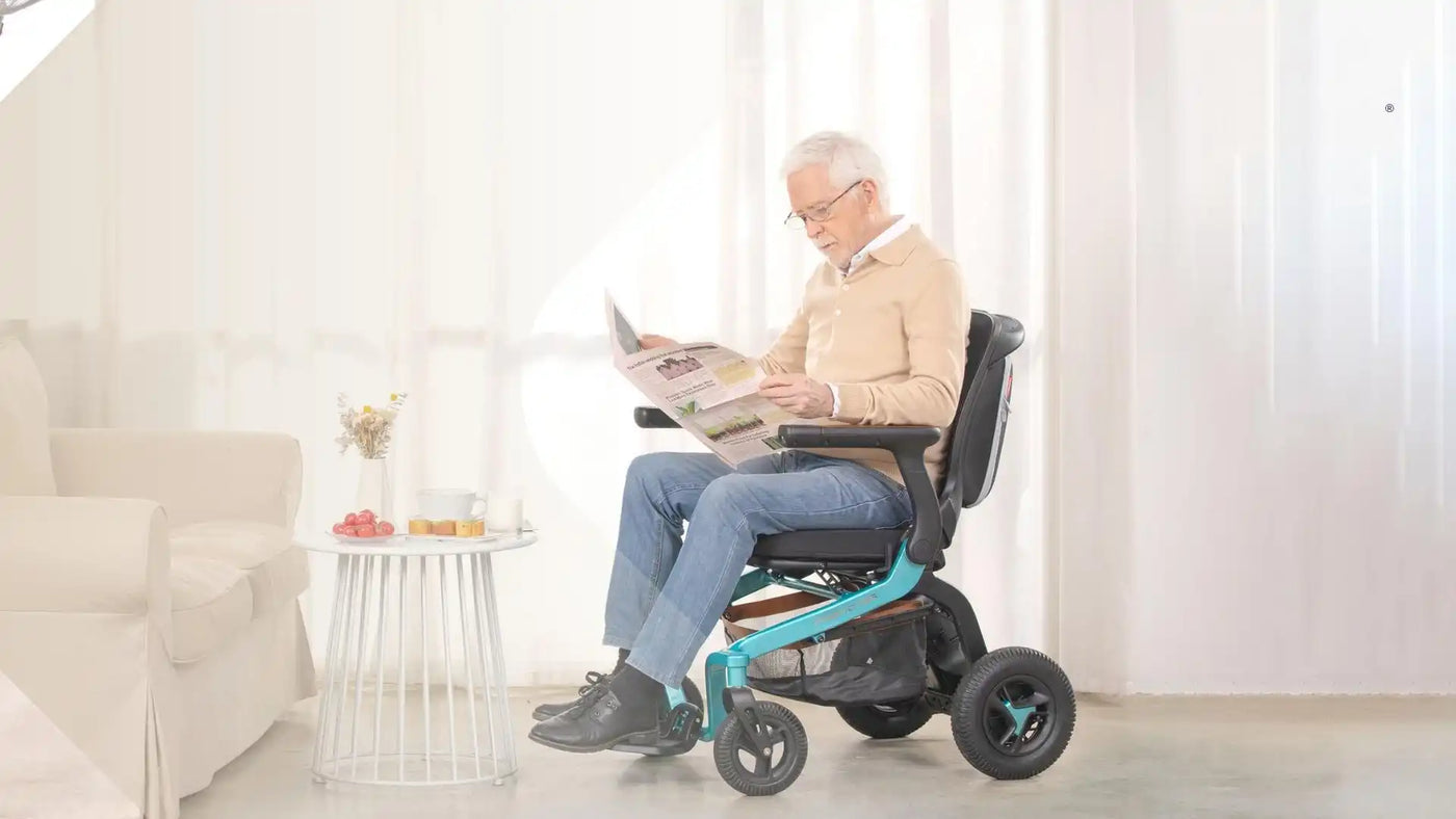 Seniorenmann in einem motorisierten Rollstuhl, der eine Zeitung liest.
