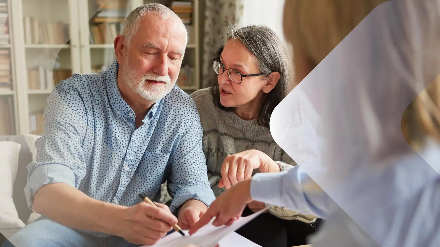 Ein älteres Paar unterschreibt Dokumente mit einem Finanzberater.
