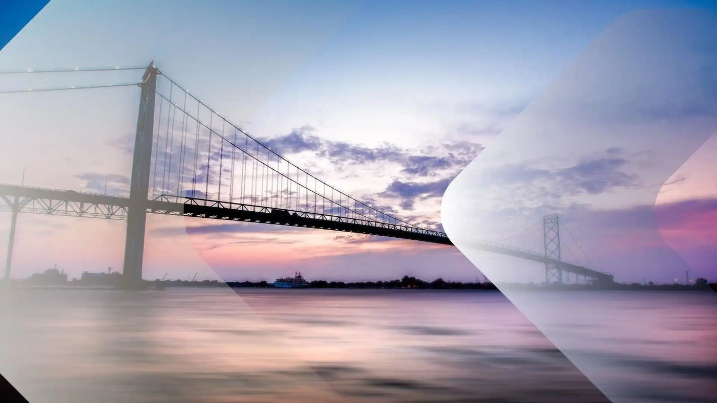 Eine lange Hängebrücke über Wasser bei Sonnenuntergang.